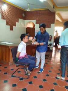 Participant helping another whose hands were tied during simulation activity to have his tea